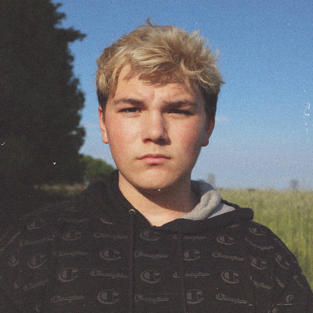 Portrait of Nathan Etes outdoors with a field behind him