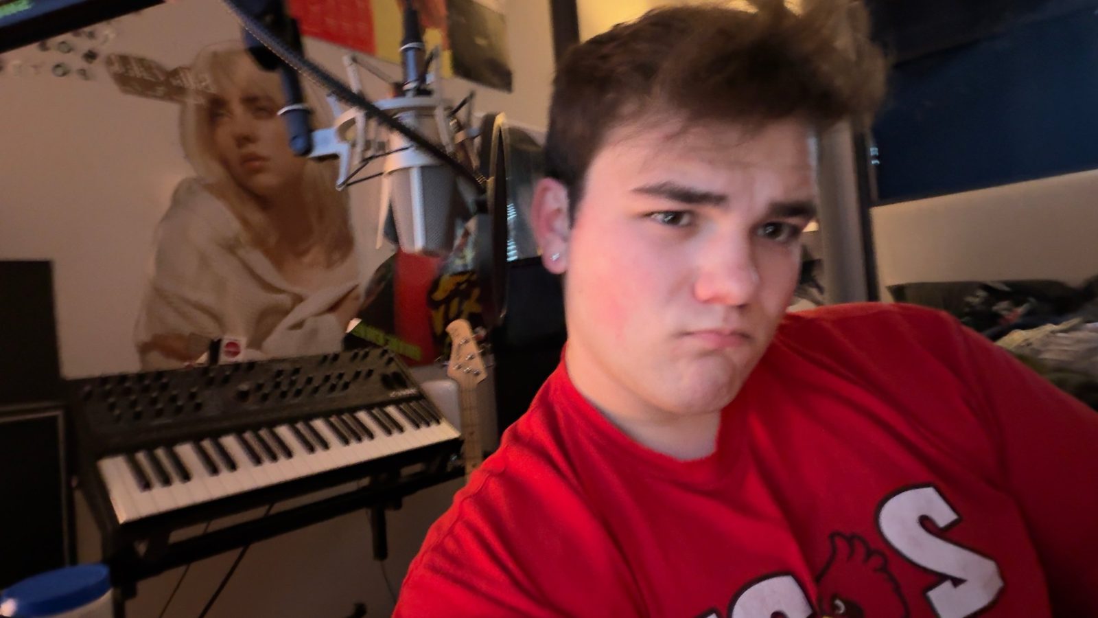 Nathan Etes in his studio with a keyboard and microphone behind him